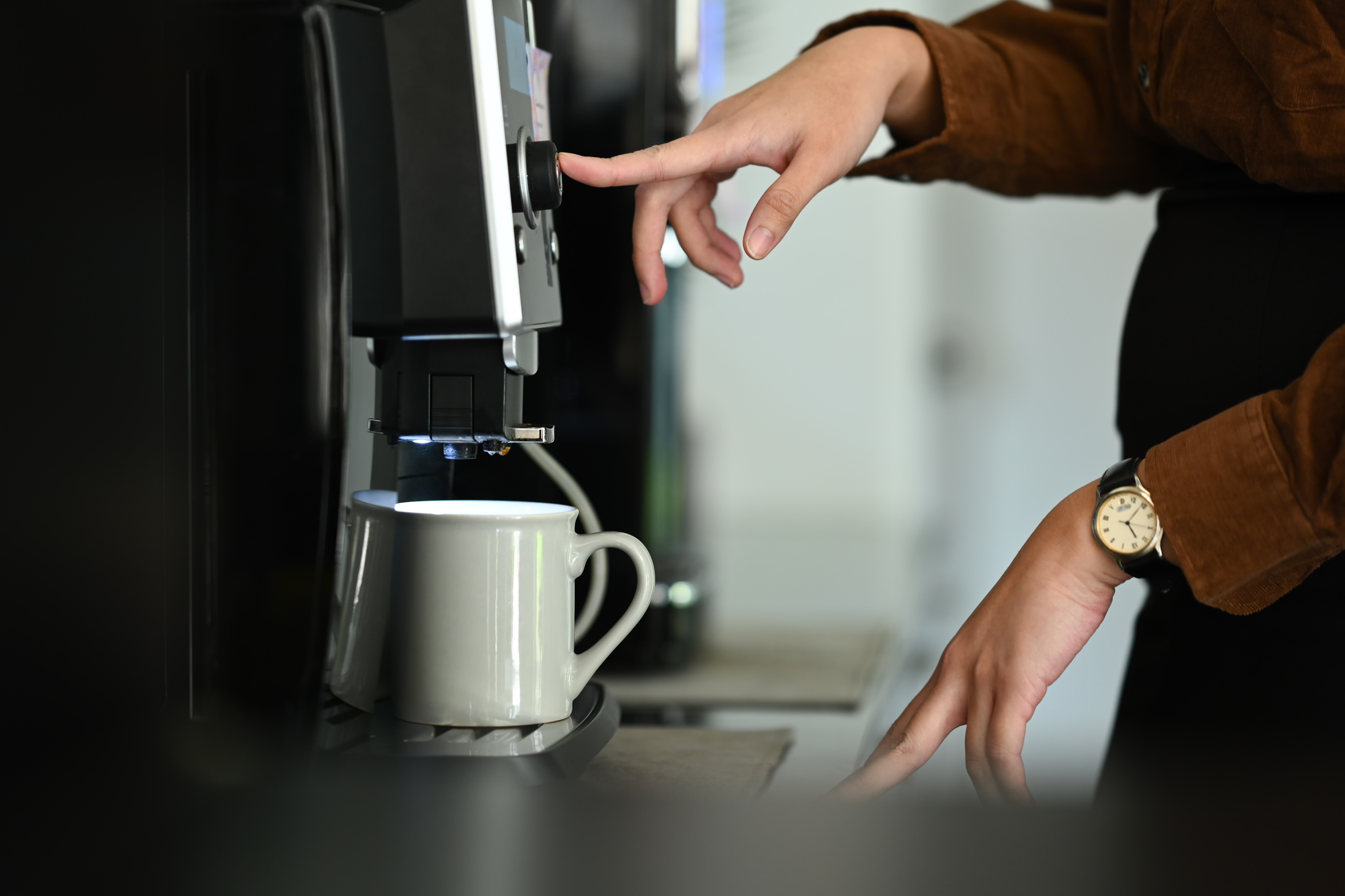 Closeup business woman using coffee machine in the office..
